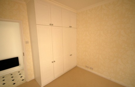 The bespoke wardrobes in the bedroom (note the wallpaper)
