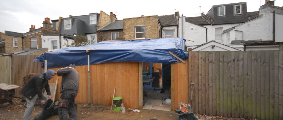 New fencing and rear patio with makeshift roof so we can work in the rain on this rear extension in Earlsfield